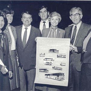 Board of Supervisors holding a poster up of new buses